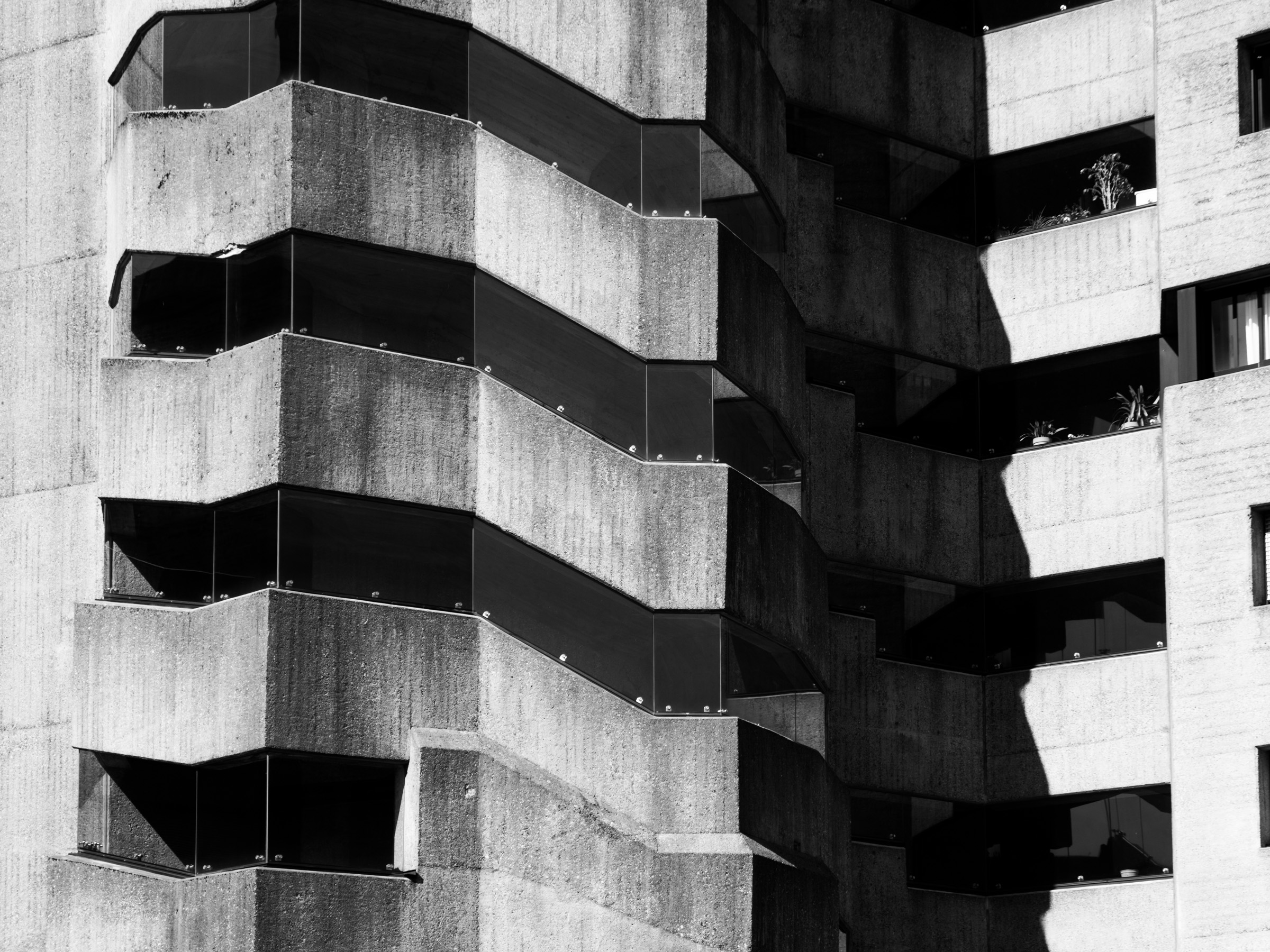 Close detail of concrete balcony edges with strong diagonal shadow