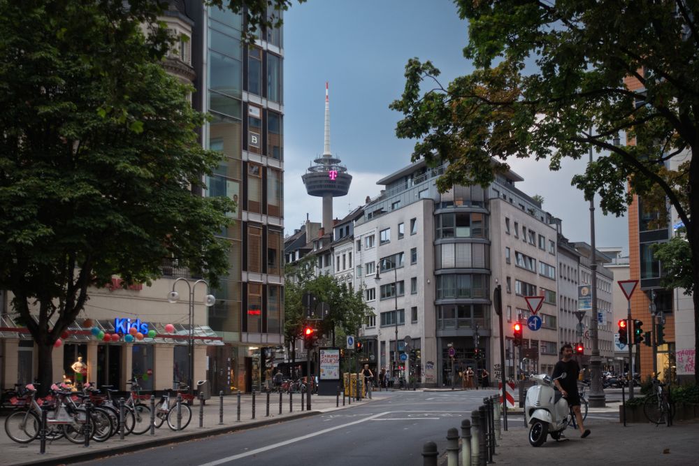 Street crossing near Friesenplatz, Cologne, with the Colonius telecommunications tower in the background