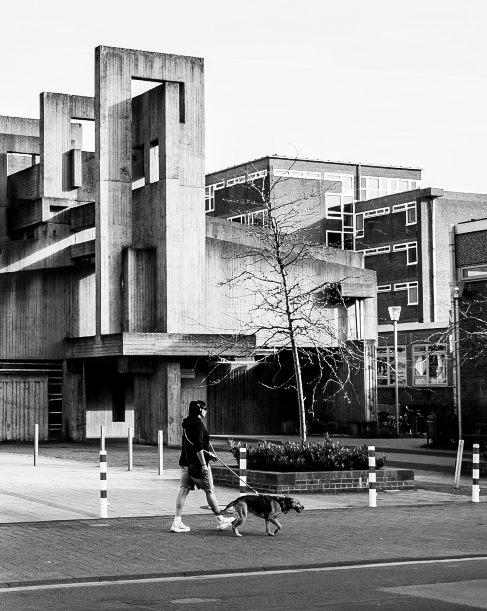 Kirche St. Johannes XXIII Köln — street view with person walking dog in front of brutalist church